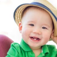 Blue eyed baby boy wearing fedora with little grin