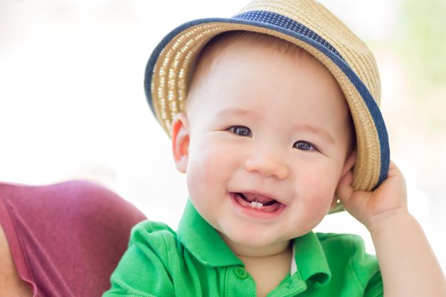 Blue eyed baby boy wearing fedora with little grin