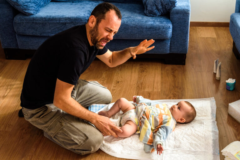 Father Changing Dirty Diaper to Put in Diaper Pail