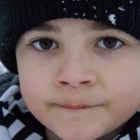 Close up of brown eyed boy in snow hat