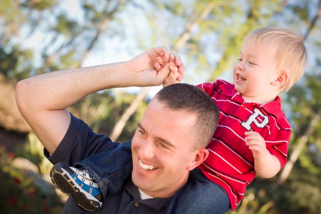 Happy father with happy toddler on shoulder