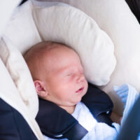 preemie baby sitting in a car seat