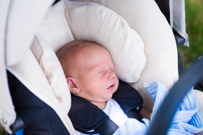 preemie baby sitting in a car seat