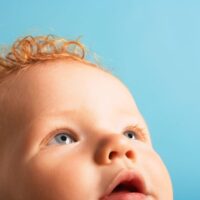 Close up of red headed baby looking up