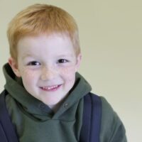 Red haired, freckled school boy with backpack