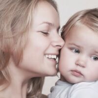 Smiling mom with blonde toddler