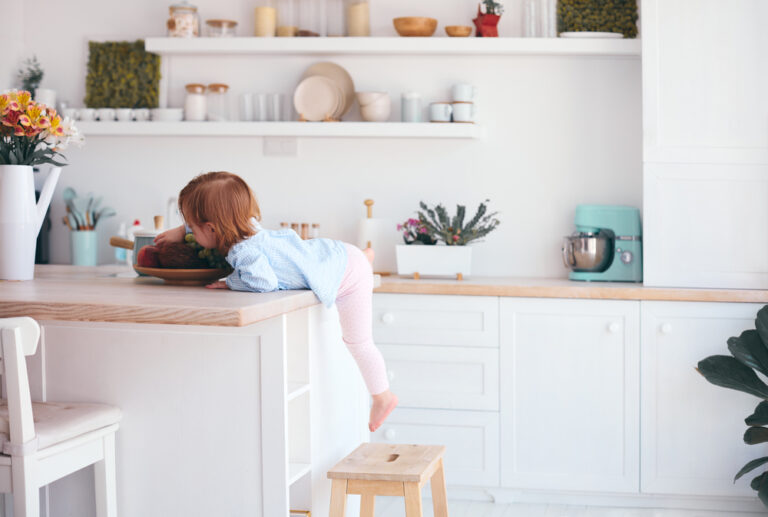 Toddler climbing on step stool