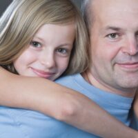 Daughter hugging dad from behind