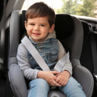 Cute toddler boy sitting in car seat