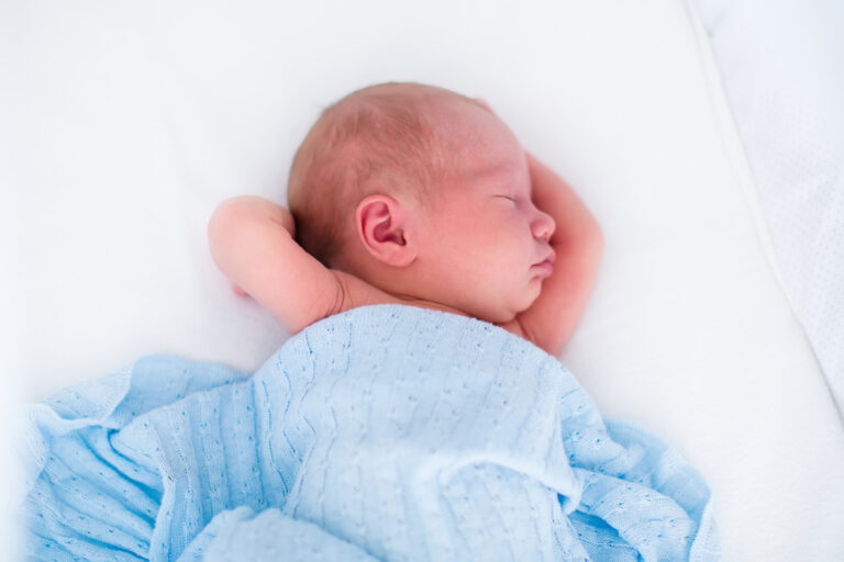 Newborn asleep in bassinet