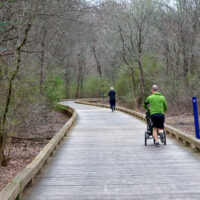 Father jogging with running stroller in park