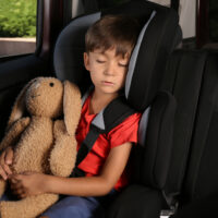 Little boy in car seat with his stuffed bunny