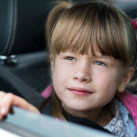 Little girl looking out the window of car