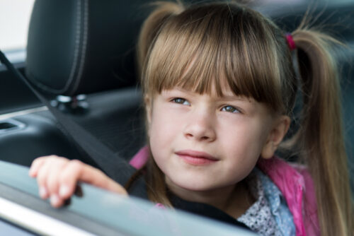 Little girl looking out the window of car