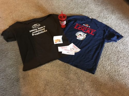 Picture of the t-shirts and other goodies Fazolis sent to Anna who loves their restaurant, and communicates despite her Angleman Syndrome condition.