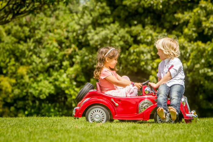 2 year old in a power wheel car outside