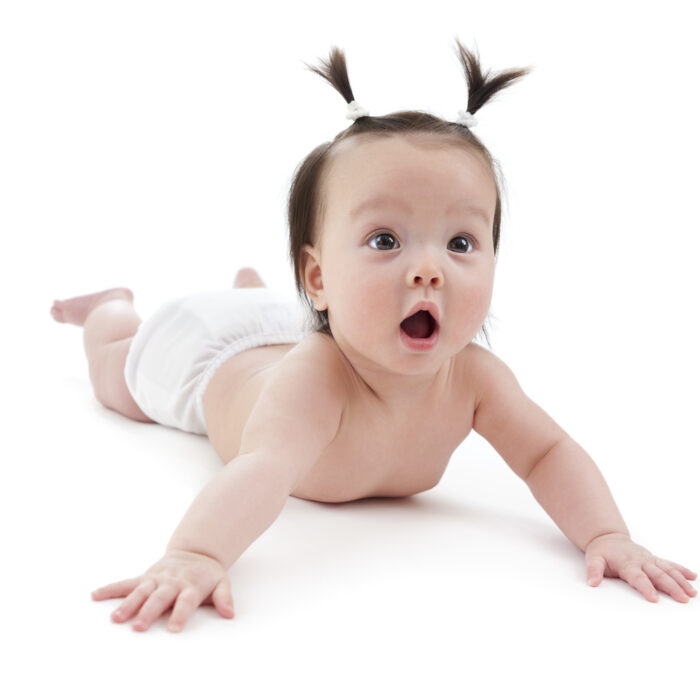 baby laying on stomach with hair pigtails