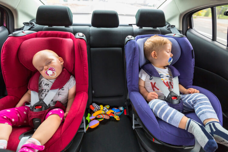 twin babies in side by side car seats