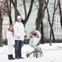 family outside in the snow with stroller