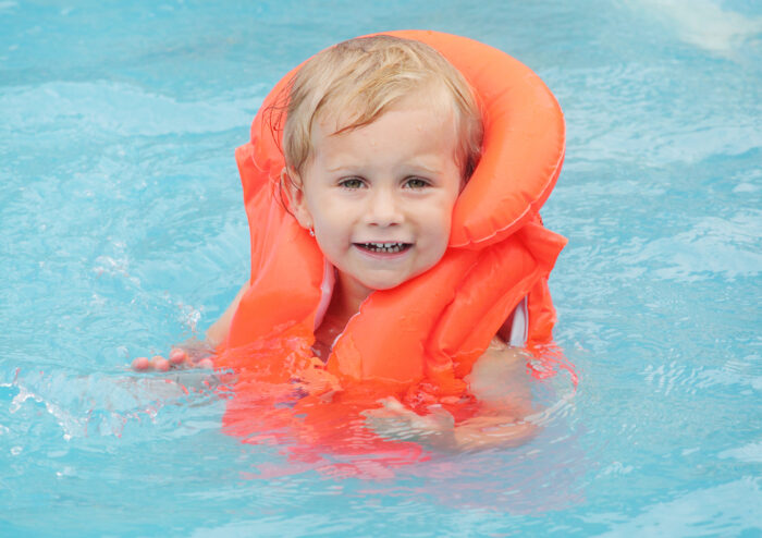 baby swimming in pool with life jacket on