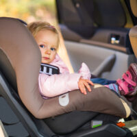 Baby Girl Peering Out Of Car Seat