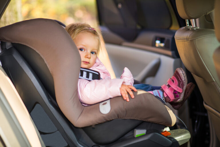 Baby Girl Peering Out Of Car Seat