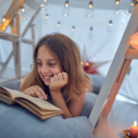 10 Year Old Girl Reading In Fort Tent