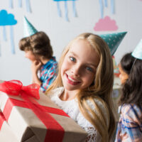 11 year old girl at a birthday party holding a gift