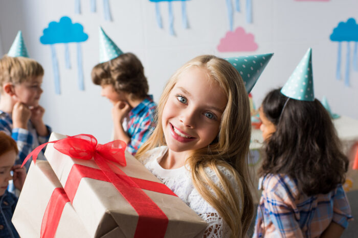 11 year old girl at a birthday party holding a gift