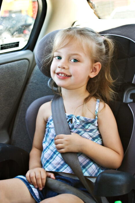 child sitting in a booster seat in the car