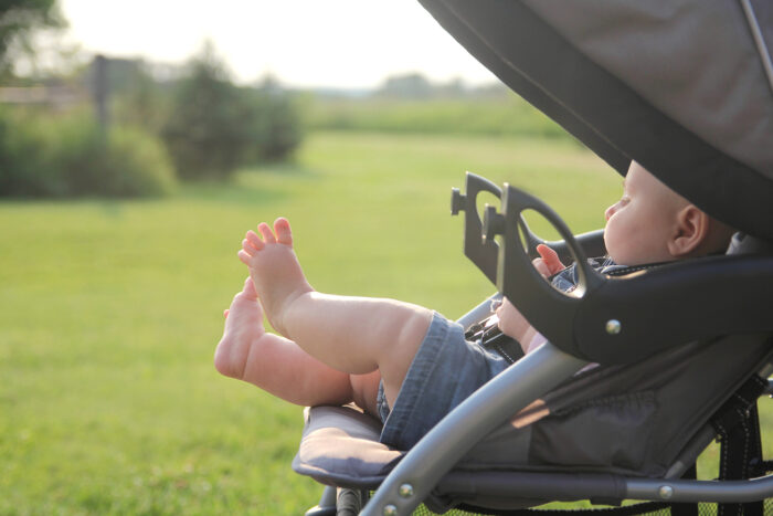 baby in a stroller with bare legs