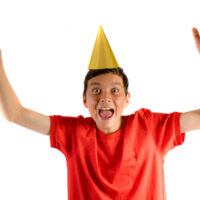 14 year old boy in party hat celebrating