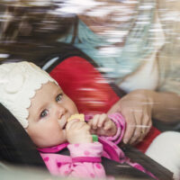 View of baby in car seat with mom through window