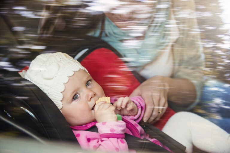 View of baby in car seat with mom through window