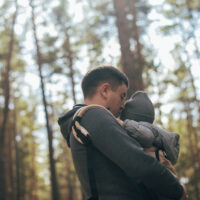 Dad Hiking with Baby in Car Carrier in Woods