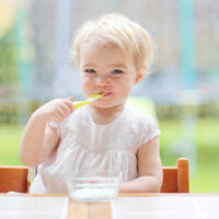 baby eating yogurt at the table