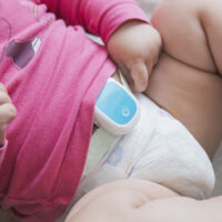 baby with breathing monitor attached to it