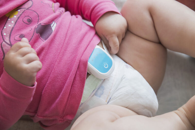 baby with breathing monitor attached to it