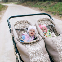 double jogging stroller with two babies in it