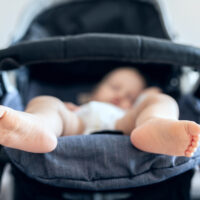 Baby asleep in stroller with close up of baby's feet