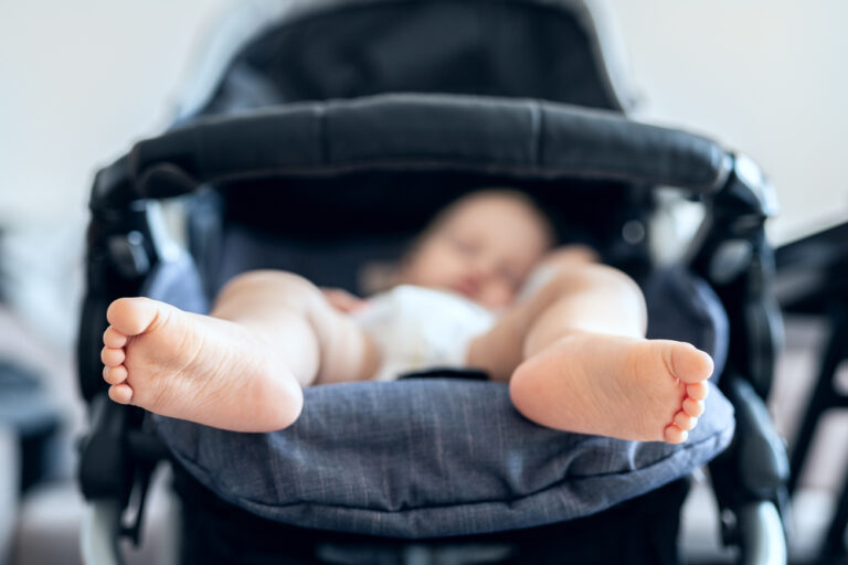 Baby asleep in stroller with close up of baby's feet