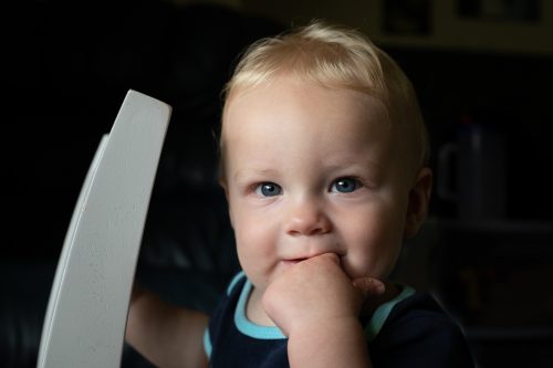 baby boy chewing on his finger in the process of teething