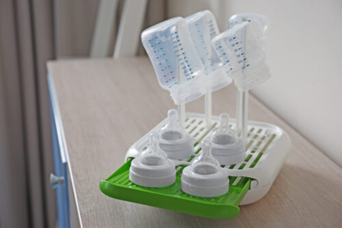 3 baby bottles and nipples on a bottle drying rack