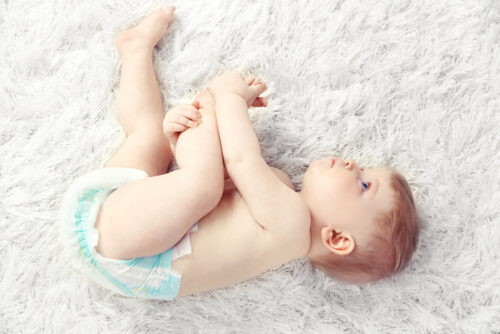 baby laying on his side wearing a diaper