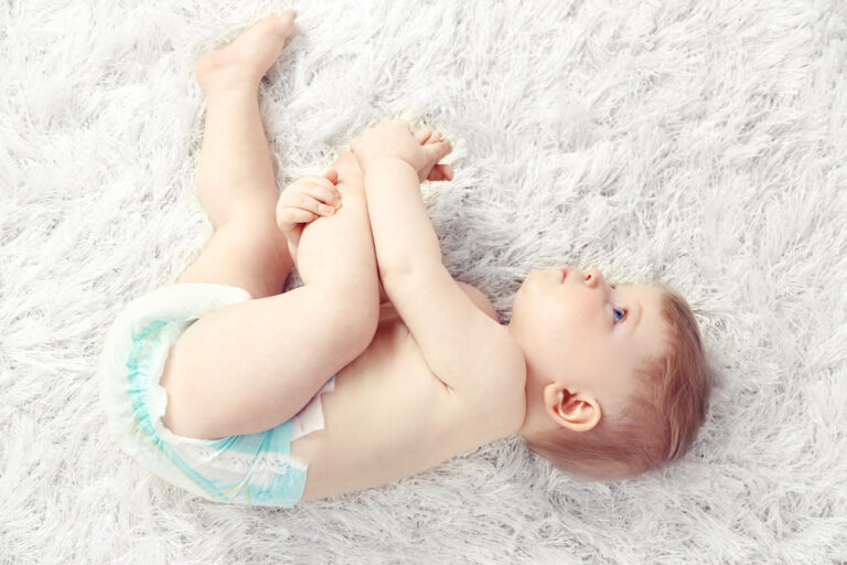 baby laying on his side wearing a diaper