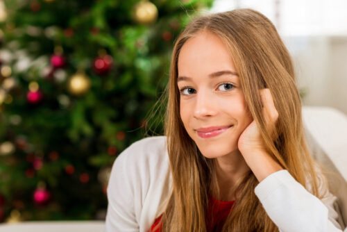15 year old girl with christmas tree in the background