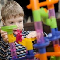 child playing with marble run toy