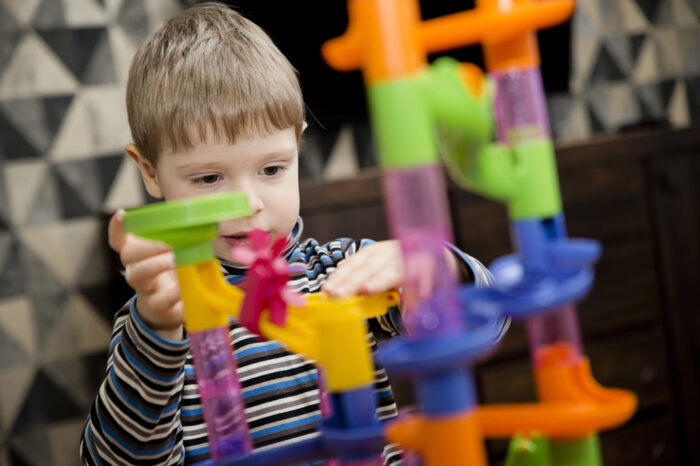 child playing with marble run toy
