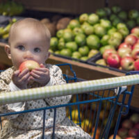 baby sitting in shopping cart