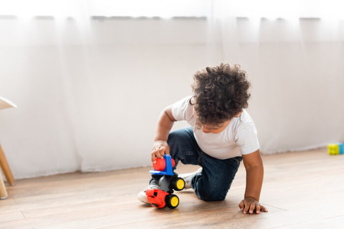 toddler boy playing with toy truck